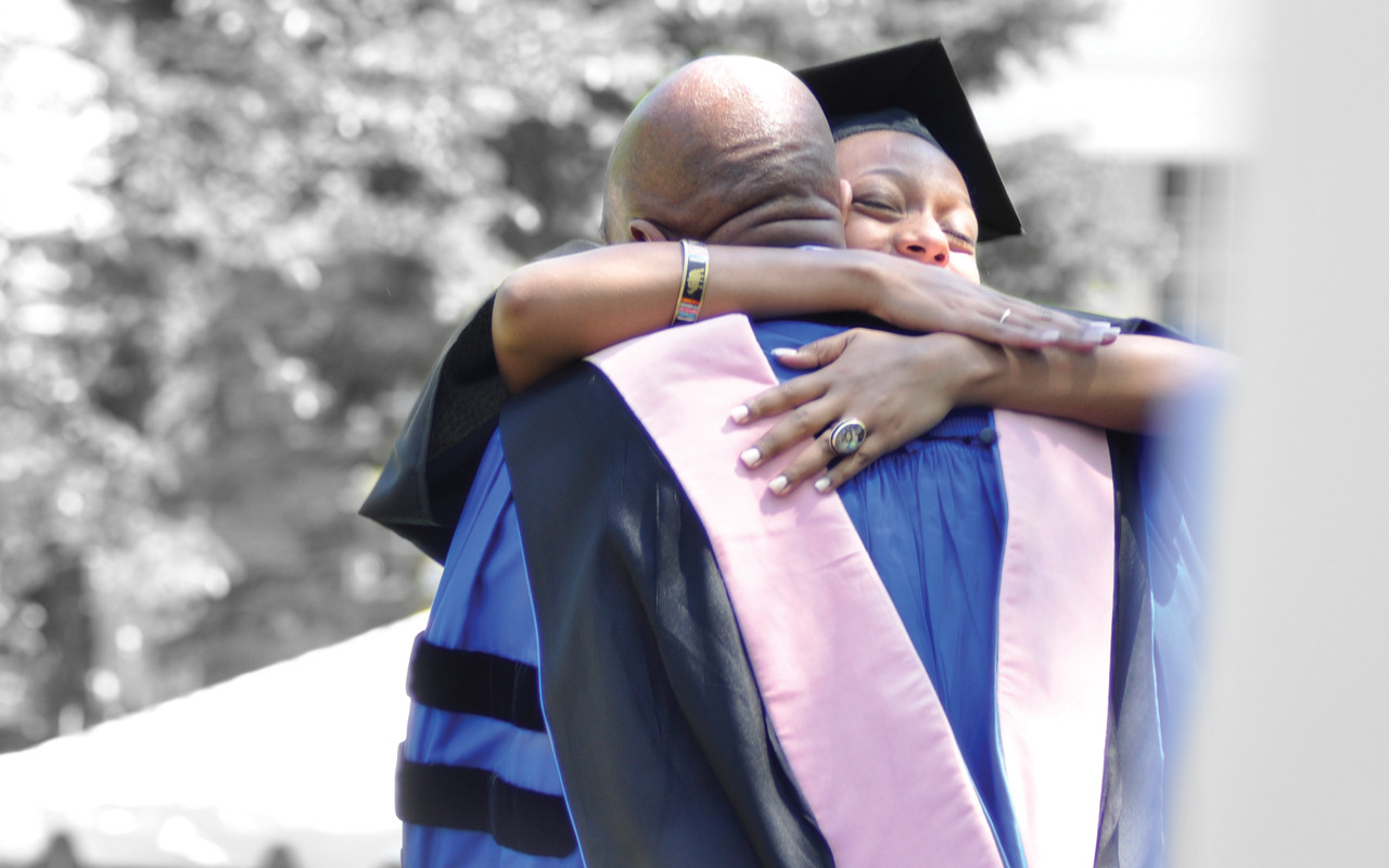 College graduate hugging professor or staff member